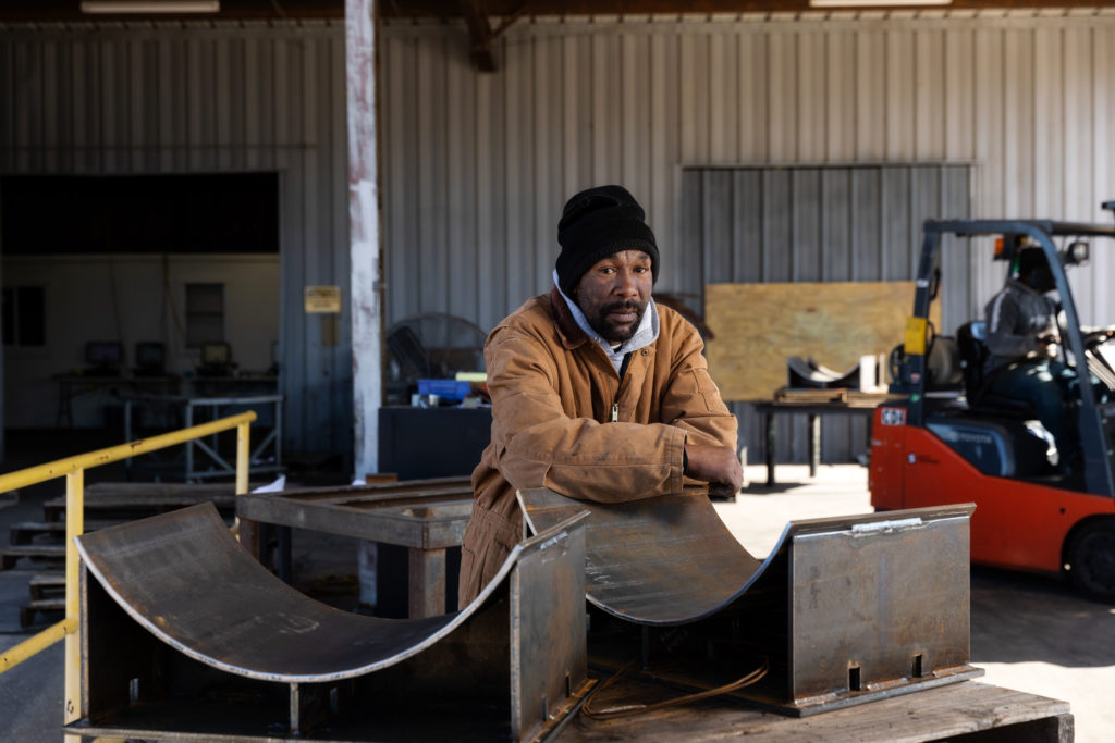 Man leans on saddle shoe, one of the many types of piping shoes.